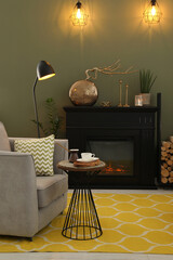 Beautiful fireplace, armchair, table and different decor in living room. Interior design
