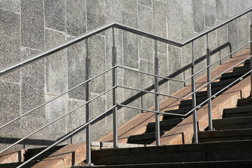 Staircase and ramp with metal handrail near building outdoors