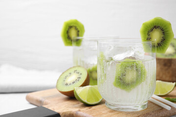 Refreshing drink, cut kiwi and lime on table. Space for text