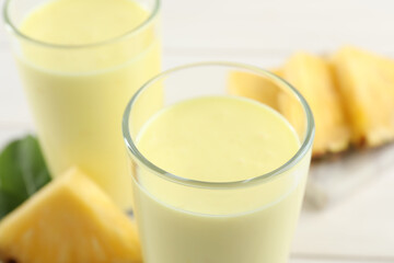 Tasty fresh pineapple smoothie on table, closeup