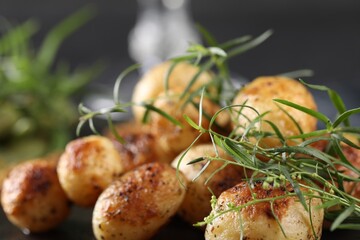 Delicious grilled potatoes with tarragon on table, closeup