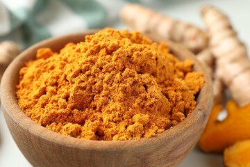 Aromatic turmeric powder in bowl on table, closeup