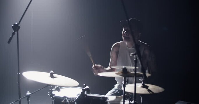 Talented male musician playing drums on stage