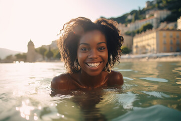 Young black woman swimming in sea, smiling