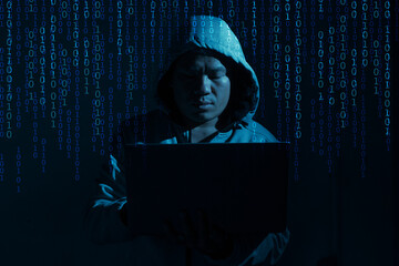 Hacker with laptop binary code dark blue color tone