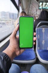young man hand using smart phone with green screen inside of metro train