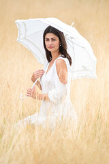 young pretty thoughtful woman with umbrella and dress