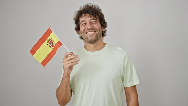 Young hispanic man smiling confident holding spanish flag over isolated white background