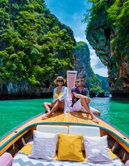 Luxury Longtail boat in Krabi Thailand, couple man, and woman on a trip at the tropical island 4 Island trip in Krabi Thailand. Asian woman and European man mid age on vacation in Thailand.