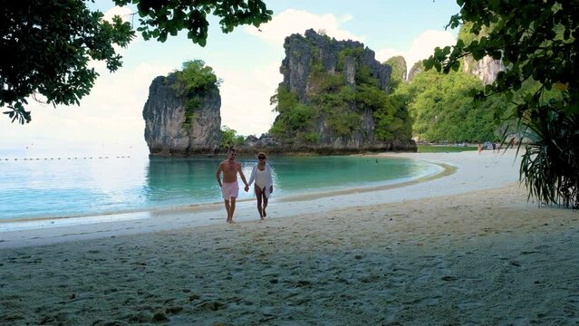 Koh Hong Island Krabi Thailand, a diverse couple of men and women on the beach of Koh Hong, a tropical white beach with Asian women and European men in Krabi Thailand on a sunny day