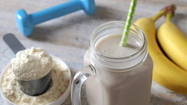 The protein drink is stirred in a glass. Fitness and healthy lifestyle concept.