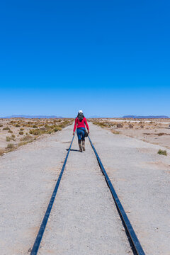 Traveling girl walking along the train tracks.