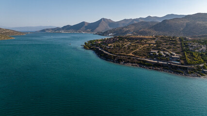 Obraz premium panoramic view of the sea bay with boats and ancient buildings on the island of Crete filmed from a drone