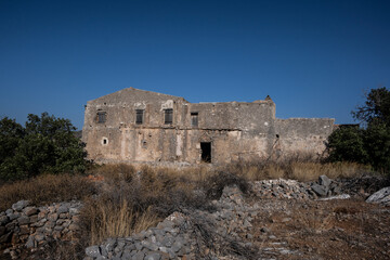 Old houses and ruins and stone churches with a sunny summer day on Crete Island