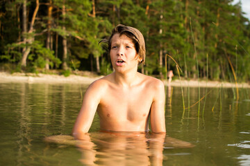 Camping weekend, teenage boy, lake and sandy shore.