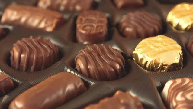 A box of chocolates pralines mix with smooth rotation motion close up view