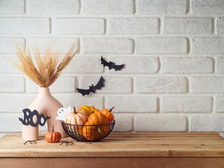  Halloween background with modern vase and decoration on wooden table over brick wall. Empty space for product display © maglara