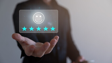 Technology customer assessment concept A close-up picture of a businessman showing satisfaction with the virtual technology with a smiley face and a five-star rating, business performance satisfaction