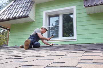 A worker greases the roof of the terrace with mastic.