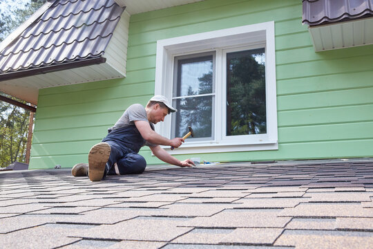 A worker greases the roof of the terrace with mastic.