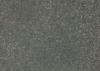 Grey rubber floor, texture, background. Dusty and worn backdrop. Faded, old, granular rubber coating. Surface with blurry sand-filled chaotic pattern. Outdoor children playground equipment