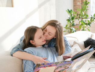 Naklejka premium Mom helping kid with homework. Woman teaching girl at home living room interior. Family study at home concept.