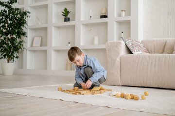 boy playing games building a tower of wooden cubes, logic game for child development. Family...