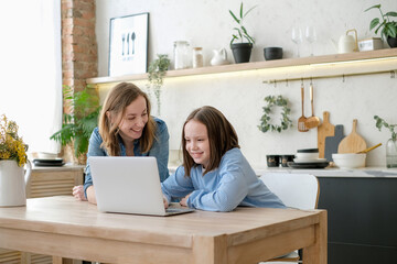 Mom helping kid with homework. Woman teaching girl at home living room interior. Family study at home concept.