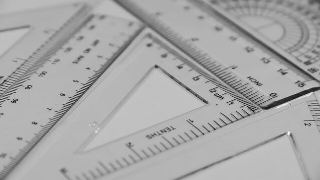 Squares, rulers and protractors on white background with slider motion. Drawing measurement tools on white background close up