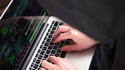 Anonymous Hooded Hacker Programming in Computer Console Breaking Password