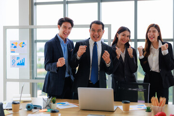 Happy Business Team of Four Professionals Celebrating Success in a Modern Office Environment, Fostering Unity and Productivity