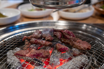 Korean Style Barbecue on stainless grill. BBQ rare meat with soft focus