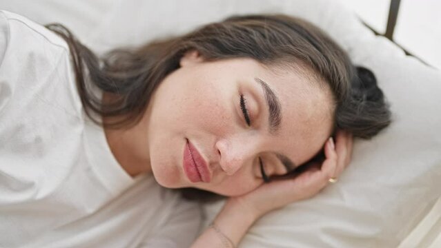 Young beautiful hispanic woman lying on bed sleeping at bedroom
