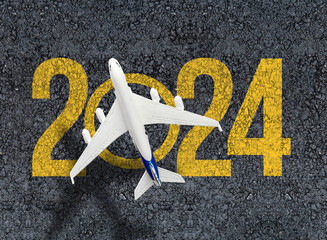 happy new year 2024. year 2024 with toy airplane over asphalt 