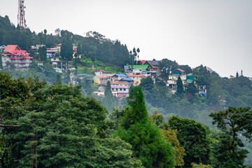 Village town of shimla darjeeling ghum ghoom on top of mountain with trees in front and mists rolling by