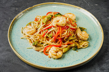 fried wok shrimp noodles on a black rustic background
