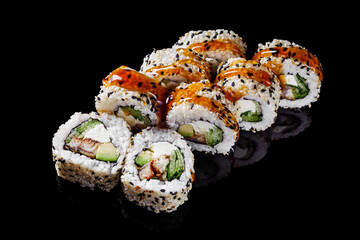 sushi roll with sesame avocado cucumber eel and Philadelphia cheese on a black mirror background
