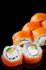 sushi roll with salmon, cream cheese, Philadelphia, avocado on a black mirror background © Narsil