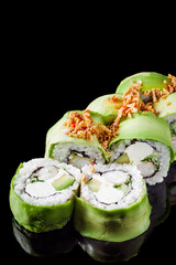 sushi roll green dragon with shrimp avocado cucumber cream cheese on a black mirror background