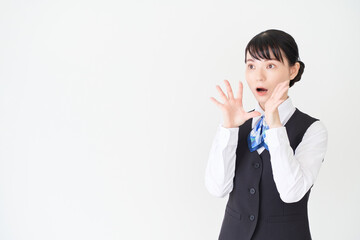 驚くポーズをするベストにリボンタイの制服を着た、受付業務、事務業務の女性