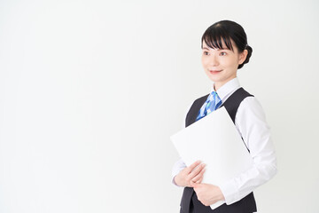 ファイルを持つベストにリボンタイの制服を着た、受付業務、事務業務の女性
