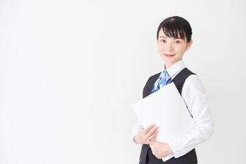 ファイルを持つベストにリボンタイの制服を着た、受付業務、事務業務の女性