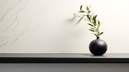 a black vase with a plant on a shelf