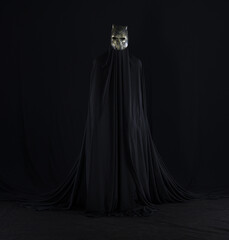 devil in a black cloak on a black background