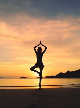 A woman practicing yoga on the beach as the sunsets in © panu101