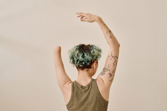 Rear view of young girl with amputee arm posing against white background