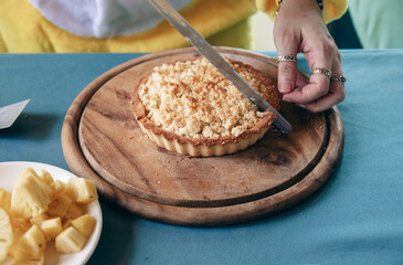 Cut pineapple cake dessert food on a cutting board.