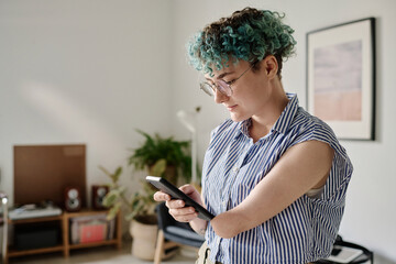 Young woman with disability using smartphone in the living room