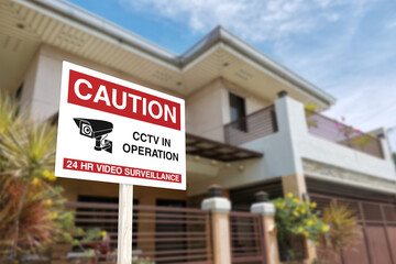 A CCTV sign in front of a gated home. Warning to visitors or burglars. Security system and protection in a residential home concept.