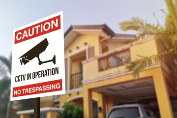 A CCTV sign in front of a gated home. Warning to visitors or burglars. Security system and...